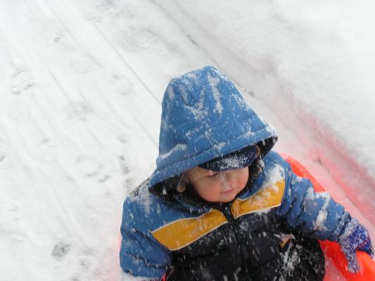 We are playing witha sled in front of our apartment.