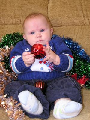 Sarah is holding a red Christmas ball