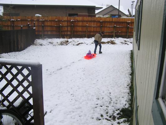 Sarah and David play with the orange sled.