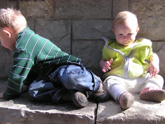 Noah and Sarah by a rock wall.