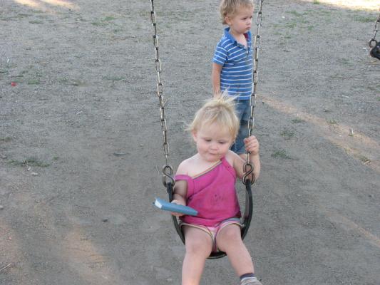 Sarah wants to swing, but she doesn't want to let go of ther Bible.