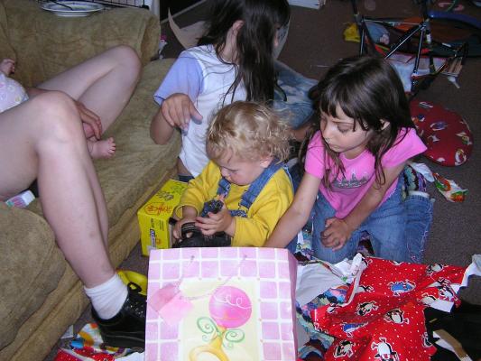 Andrea helps Noah open some more gifts.