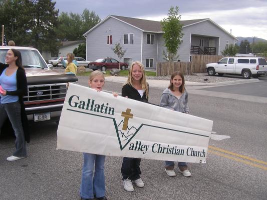 Amie, friend and Jennah hold the GAllatin Valley Christian Church sign for the parade