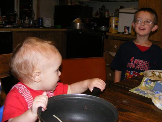Noah laughs at his brother Joshua's eating habits. 