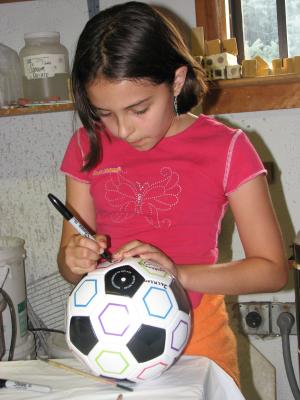Malia signing the soccer ball.
