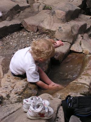 Noah plays in the puddle.