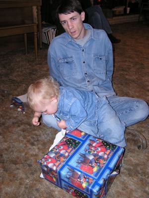 Noah opens a present from great grandma and great grandpa.