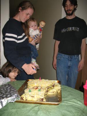 Katie lights Sarah's first birthday cake.