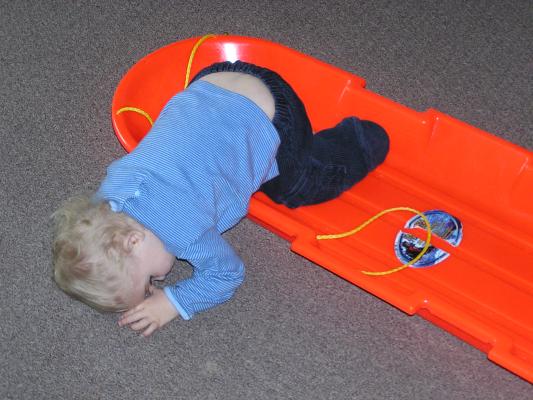 Noah plays with his sled.