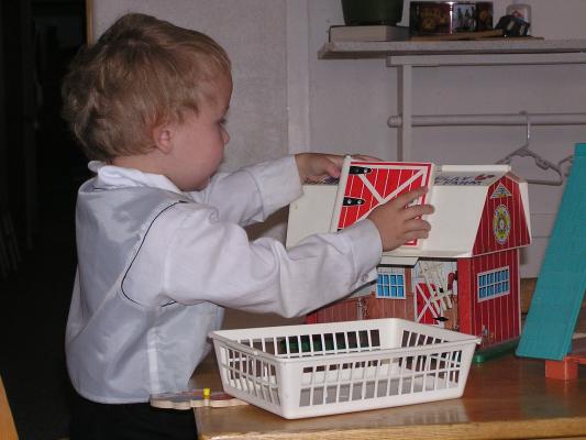 Noah plays with a barn