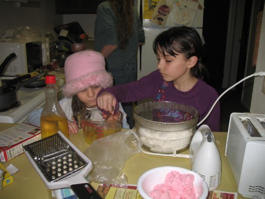 Malia and Andrea help bake the cake.