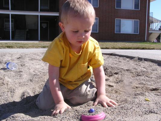 Noah buries stuff in the sand.
