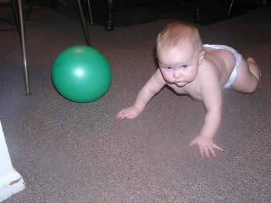 Sarah plays with a green baloon.
