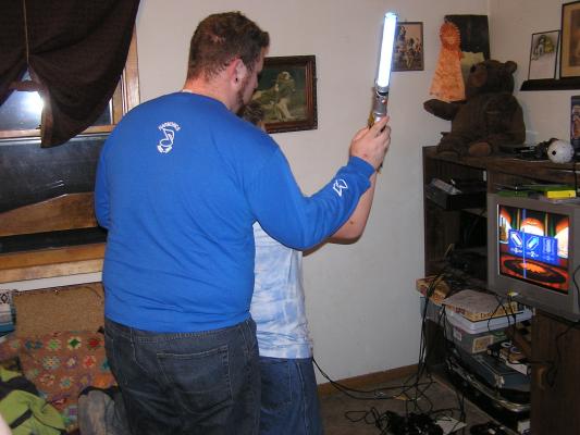 Titus plays a Star Wars game with a light saber.