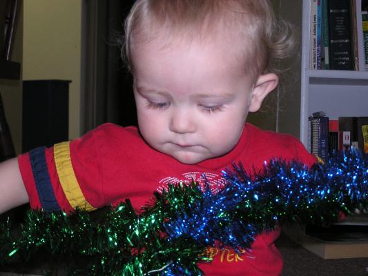 Noah plays with green and blue tinsel.