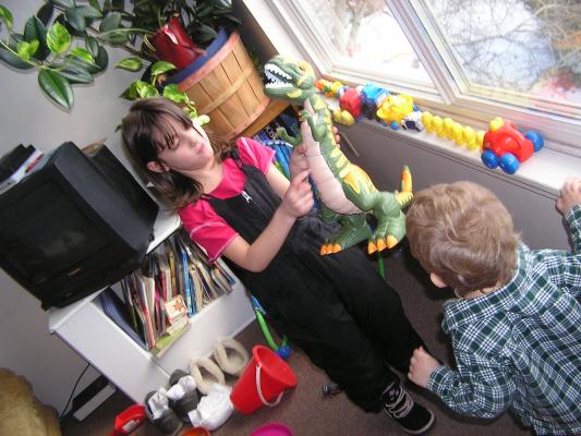 Andrea and Noah play with cars and dinosaurs.