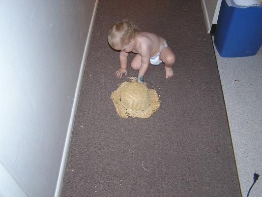 Noah plays with an old straw hat.