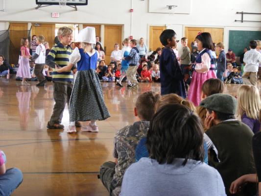 First graders do an international day dance.