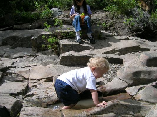 Noah goes swimming at the top of the falls.