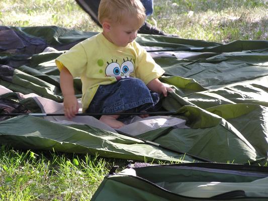 Noah puts the pole through the tent.