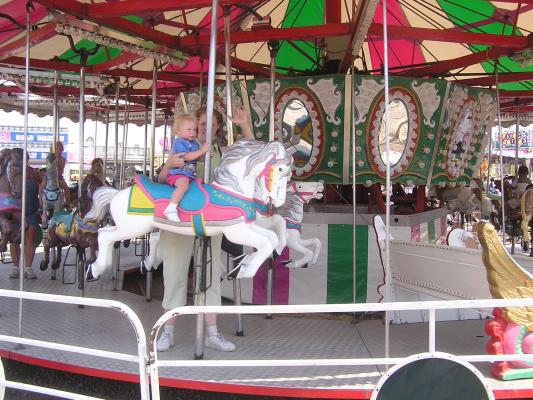 Sarah riding the carousel at the fair.