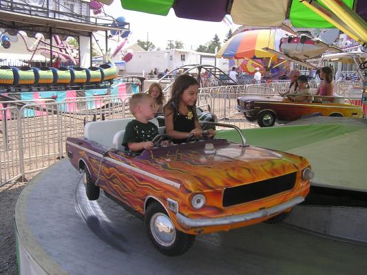 Noah and Andrea in a car at the carnival.