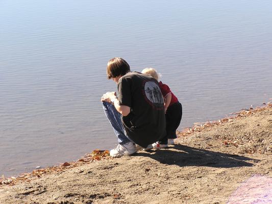 David and Noah look into the water at the lake.