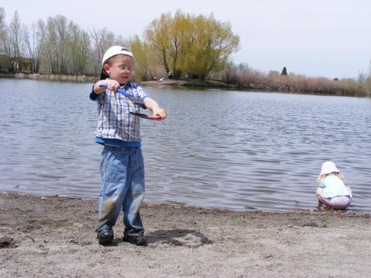 Noah uses ice scrapers to play at Bozeman Pond.
