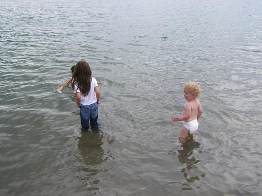 Malia, Andrea, and Noah play in the lake.