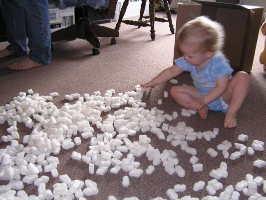 Noah plays with styrofoam peanuts.