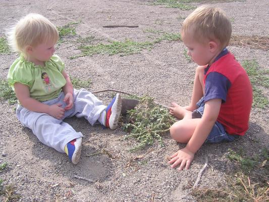 Sarah and Noah play in the sand at the park.