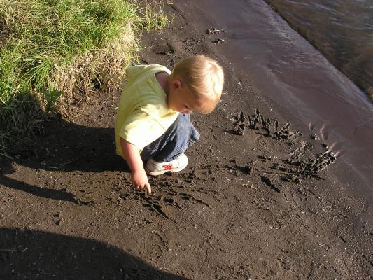 Noah draws in the sand on the bank of the Yellowstone River.