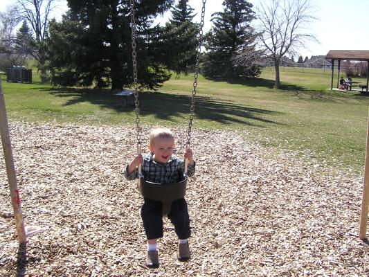 Noah swings at the park.
