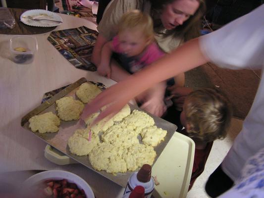 Joe removes candles from the cake while Katie helps Noah and Sarah.