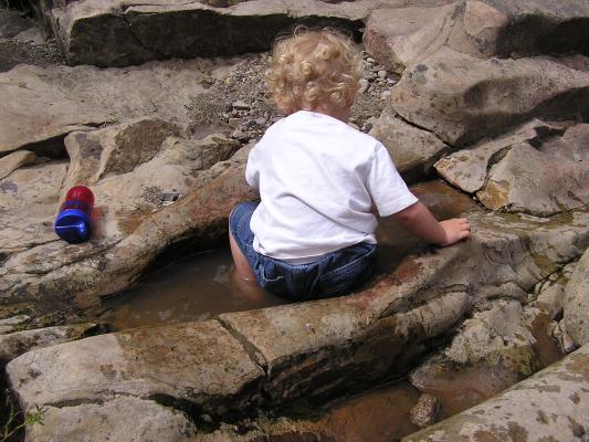 Noah sits in the water.