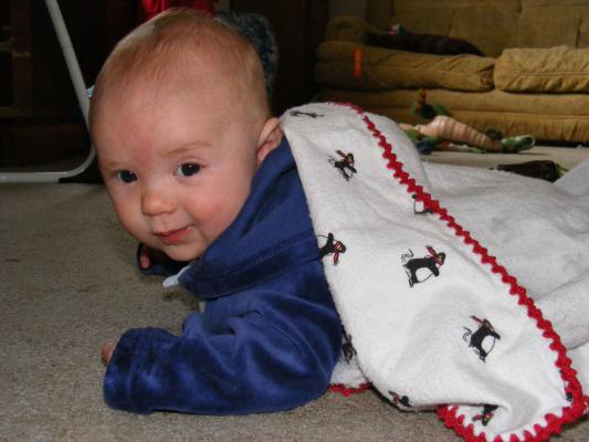 Joshua on his tummy smiling a little bit.