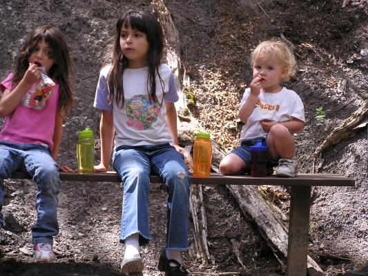 Andrea, Malia and Noah take a break on a bench.