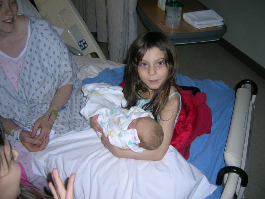 Andrea holds Sarah on the hospital bed.