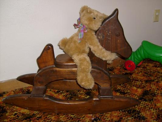 The bear plays on the rocking horse