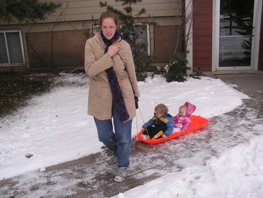 Katie  pulls Noah and Sarah in the sled.