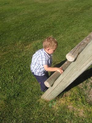 Noah climbes the swing set at a pavilion where our neighbors got married.