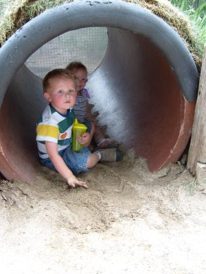 Noah and Sarah play in the sand of the badger hole