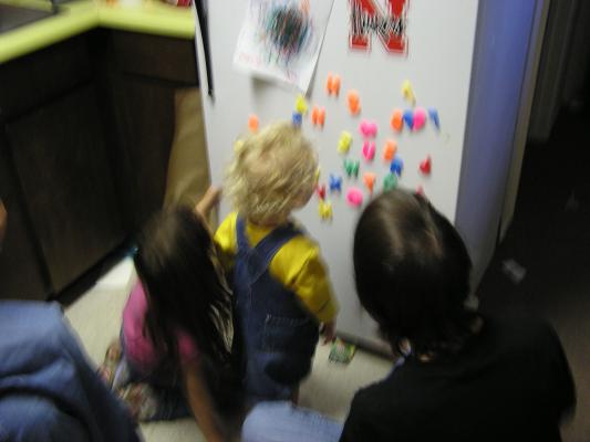 Noah plays with the letters on the fridge.