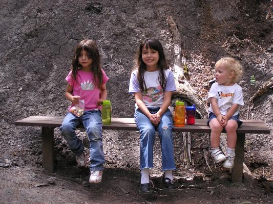 Andrea, Malia and Noah take a break on a bench.