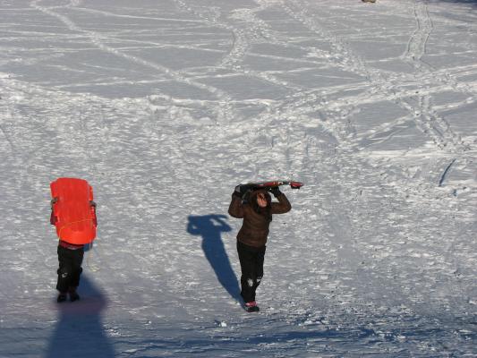 Andrea and Malia carry the sleds back up the hill.