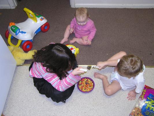 Andrea, Sarah, and Noah each have a spoon with  which to eat fruity balls.