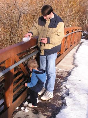 David sets up some ice for Noah to knock into the river.