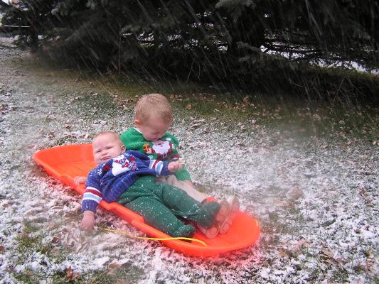Sarah and Noah get pictures on a sled.