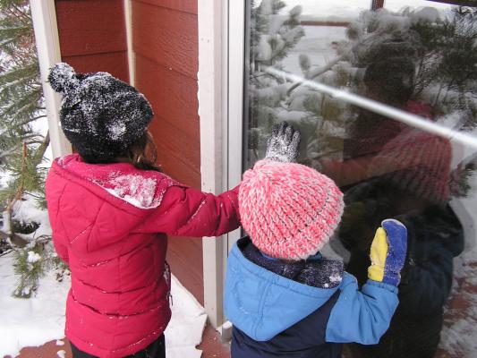 Andrea and Noah play with their reflections in the window.