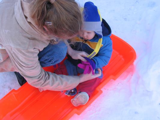 Noah gets some gloves on to go sledding.